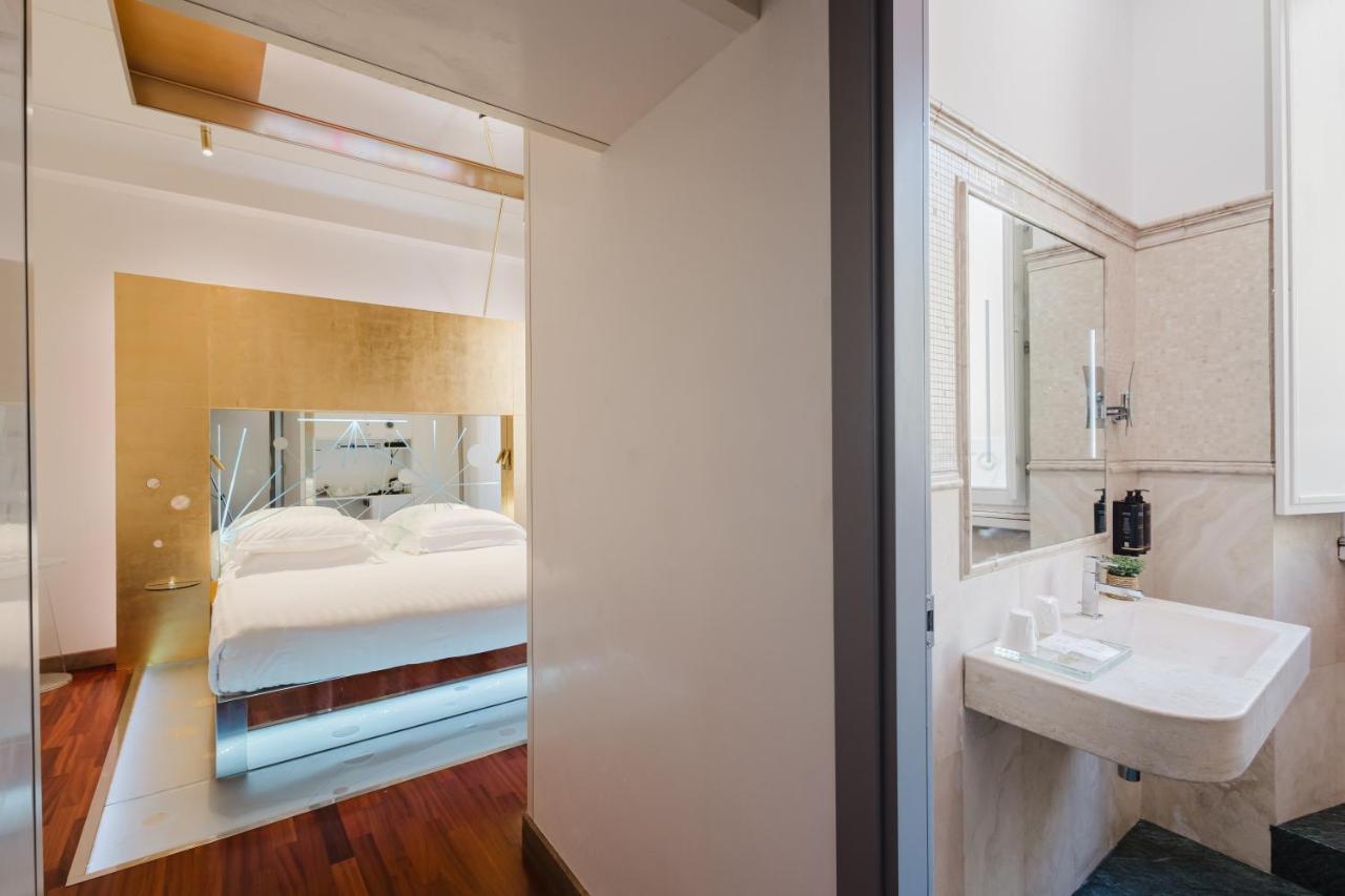 een slaapkamer met een bed en een badkamer met een wastafel bij Hotel Trecento in Rome +98 foto's