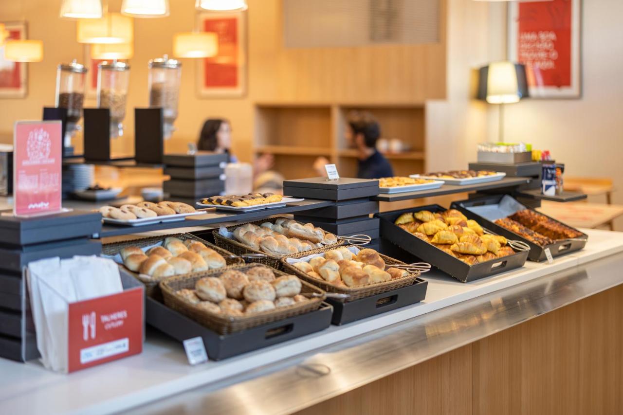 een bakkerijtoonbank met veel verschillende soorten gebak bij Moov Hotel Porto Centro in Porto