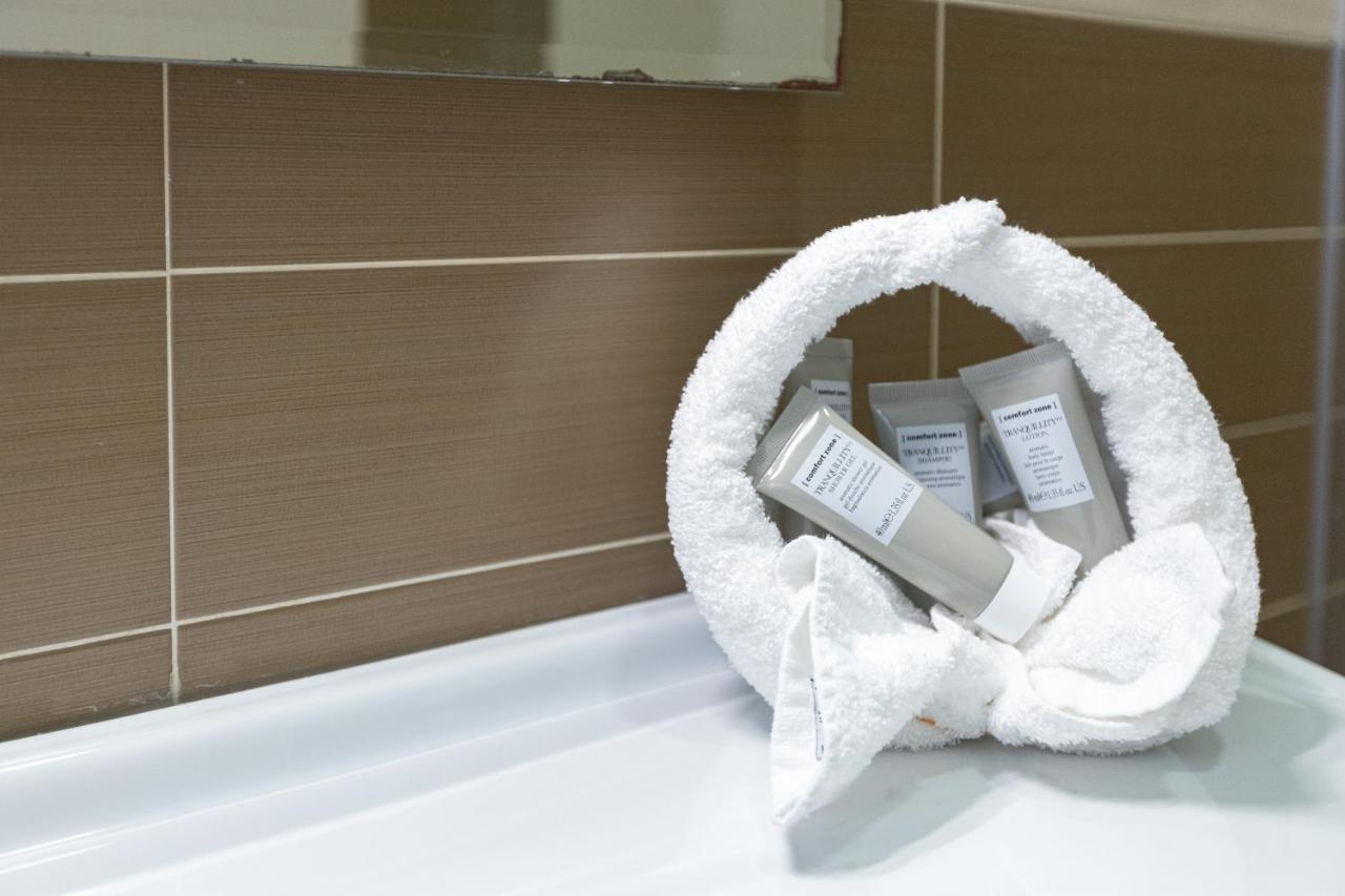 een badkamer met een badkuip, handdoeken en toiletartikelen bij diVino Hotel in Rilievo