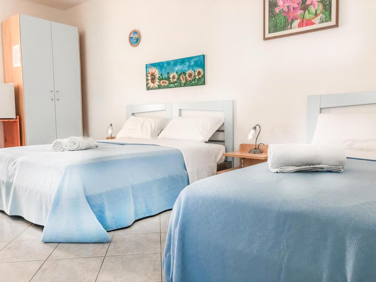 twee bedden die naast elkaar in een kamer staan bij Hotel I Colori Del Mare in Torre Mozza