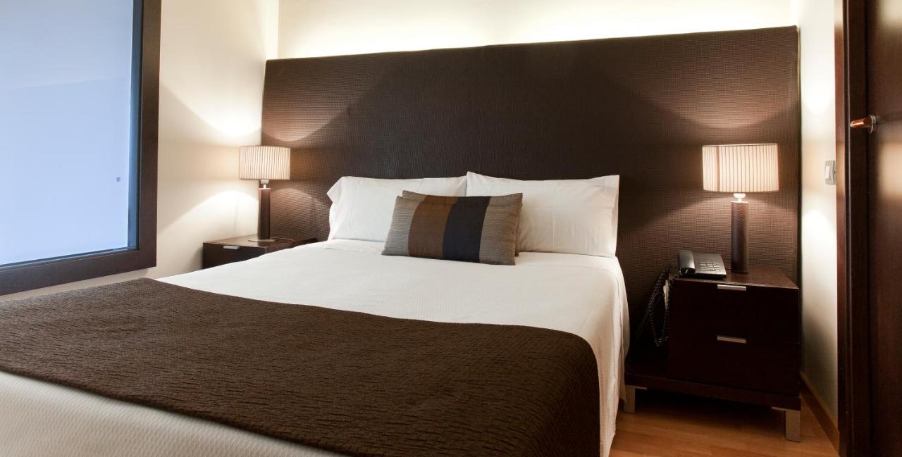 een slaapkamer met een groot wit bed en twee lampen bij Senator Barcelona Apartments in Barcelona