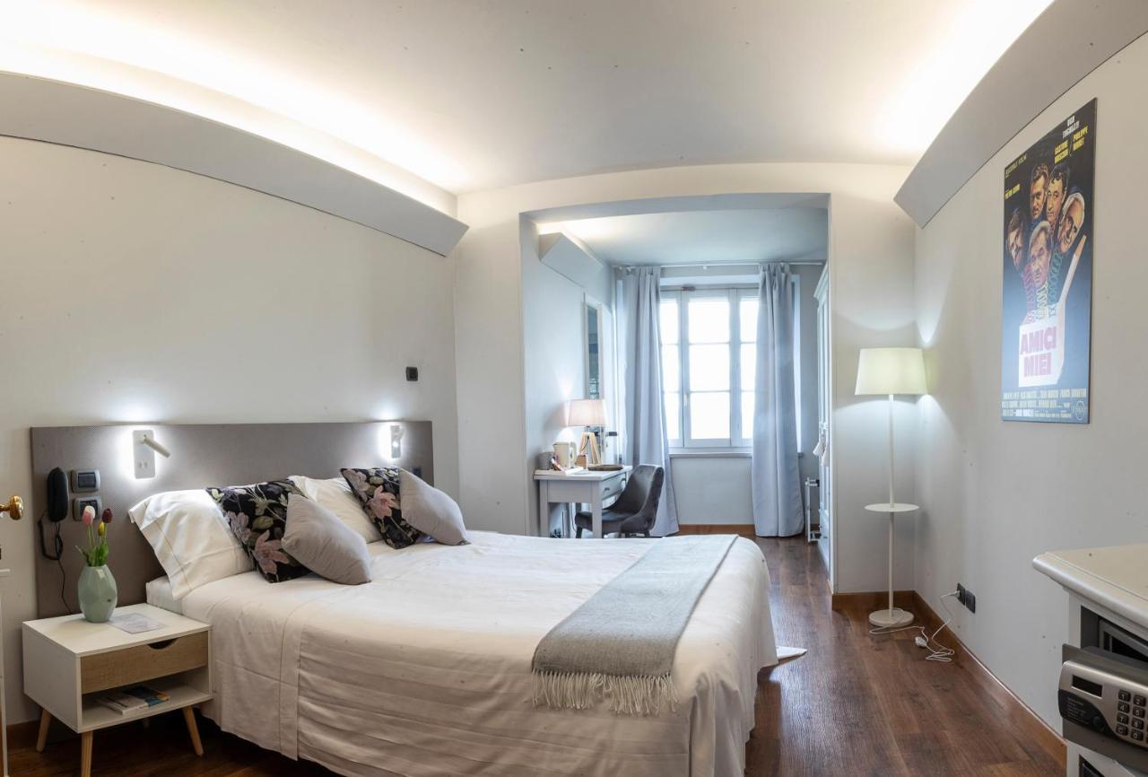 een witte slaapkamer met een groot bed en een bureau bij Locanda agli Amici in Cortona +50 foto's