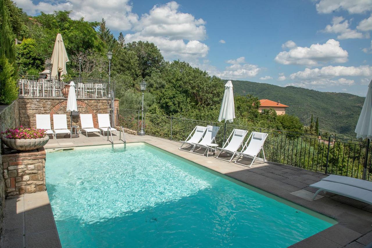 een zwembad met ligstoelen en parasols bij Locanda agli Amici in Cortona