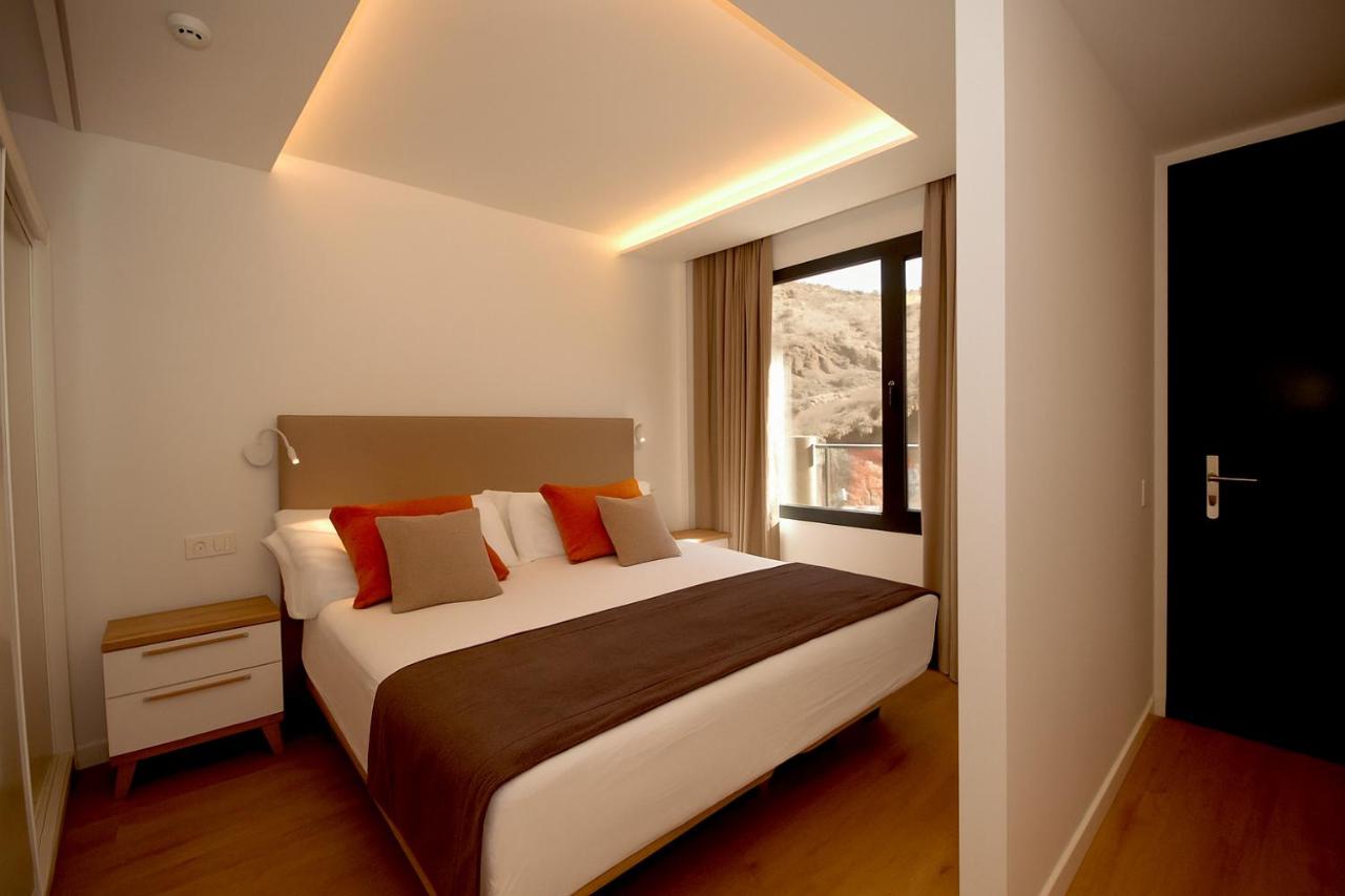 een slaapkamer met een groot bed en een raam bij Apartamentos Natural Park in Puerto Rico de Gran Canaria