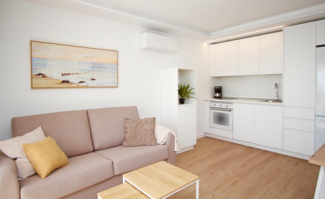 een woonkamer met een bank en een keuken bij Apartamentos Natural Park in Puerto Rico de Gran Canaria