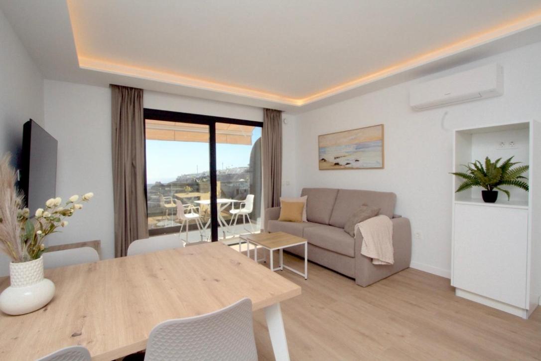 een woonkamer met een tafel en een bank bij Apartamentos Natural Park in Puerto Rico de Gran Canaria