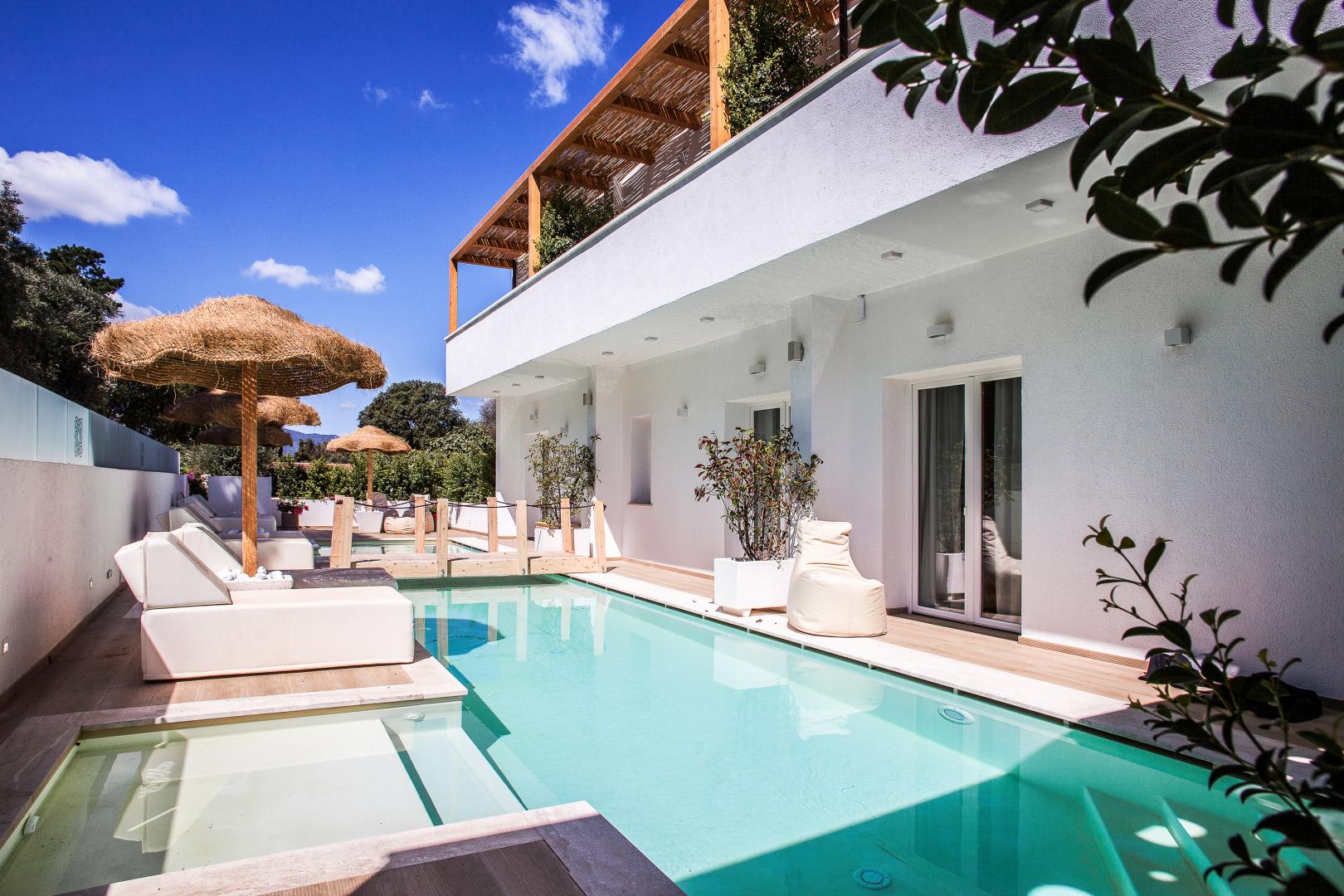 Buitenzwembad met ligbedden — Noha Lifestyle Hotel
