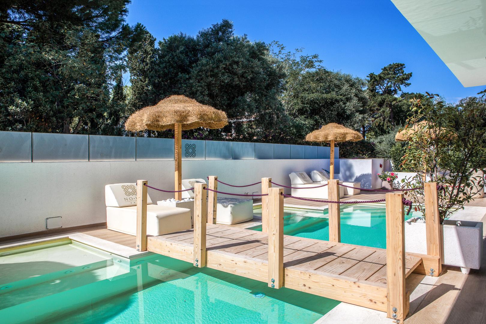Buitenzwembad met ligbedden — Noha Lifestyle Hotel