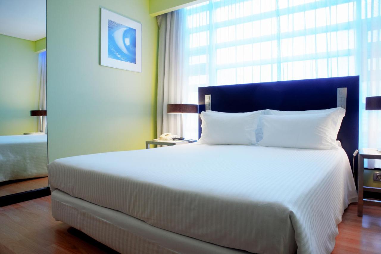 een slaapkamer met een groot wit bed en een groot raam bij SANA Capitol Hotel in Lissabon