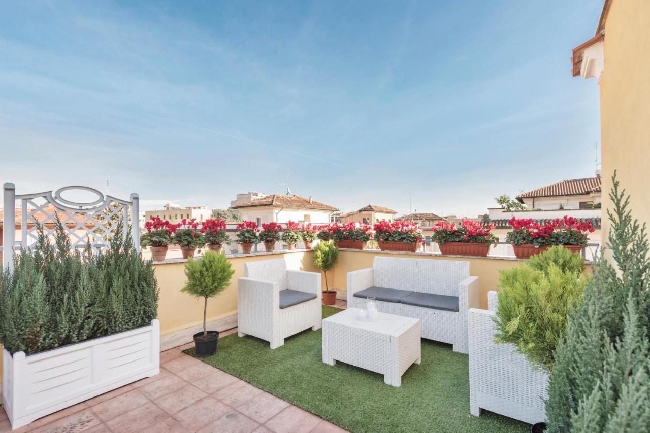 een dakterras met wit meubilair en planten bij Hotel Infinito - Gruppo BLAM HOTELS in Rome