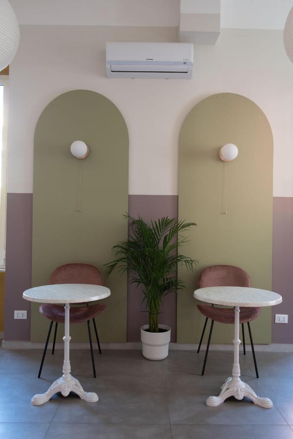 Twee tafels en stoelen in een kamer met een plant. bij Hotel Infinito - Gruppo BLAM HOTELS in Rome