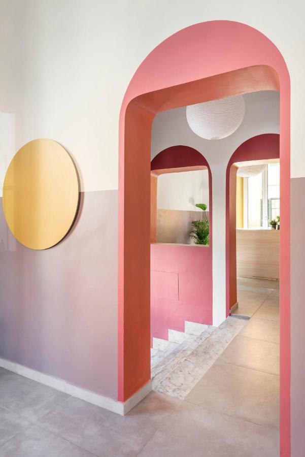 een kamer met een roze deur en een spiegel bij Hotel Infinito - Gruppo BLAM HOTELS in Rome