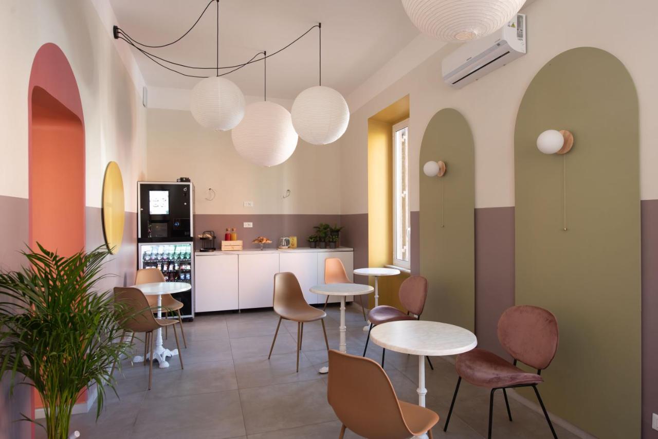 een kamer met tafels en stoelen en een keuken bij Hotel Infinito - Gruppo BLAM HOTELS in Rome
