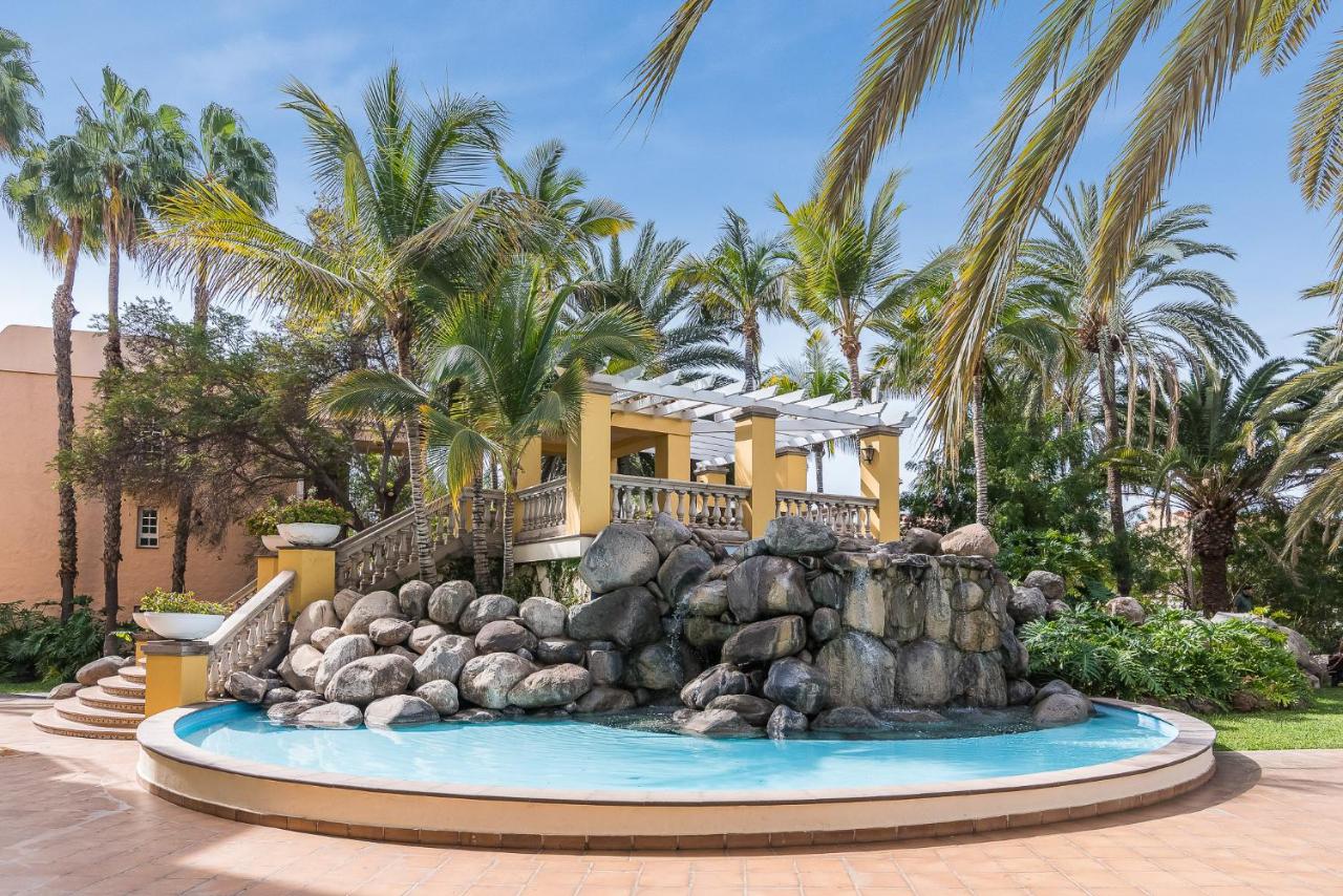 een huis met een fontein ervoor bij Palm Oasis Maspalomas in Maspalomas