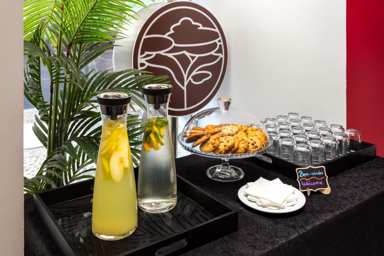 een tafel met twee vazen en een schaal met eten bij Hotel Luena in Lissabon