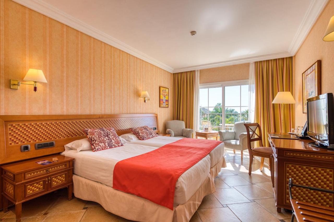 een hotelkamer met een bed en een televisie bij Hotel Cordial Mogán Playa in Puerto de Mogán