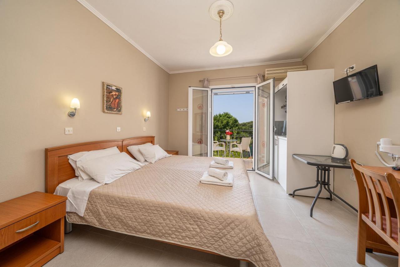 een slaapkamer met een bed, een tafel en een balkon bij Dionysios Studios in Skála Kefalonias