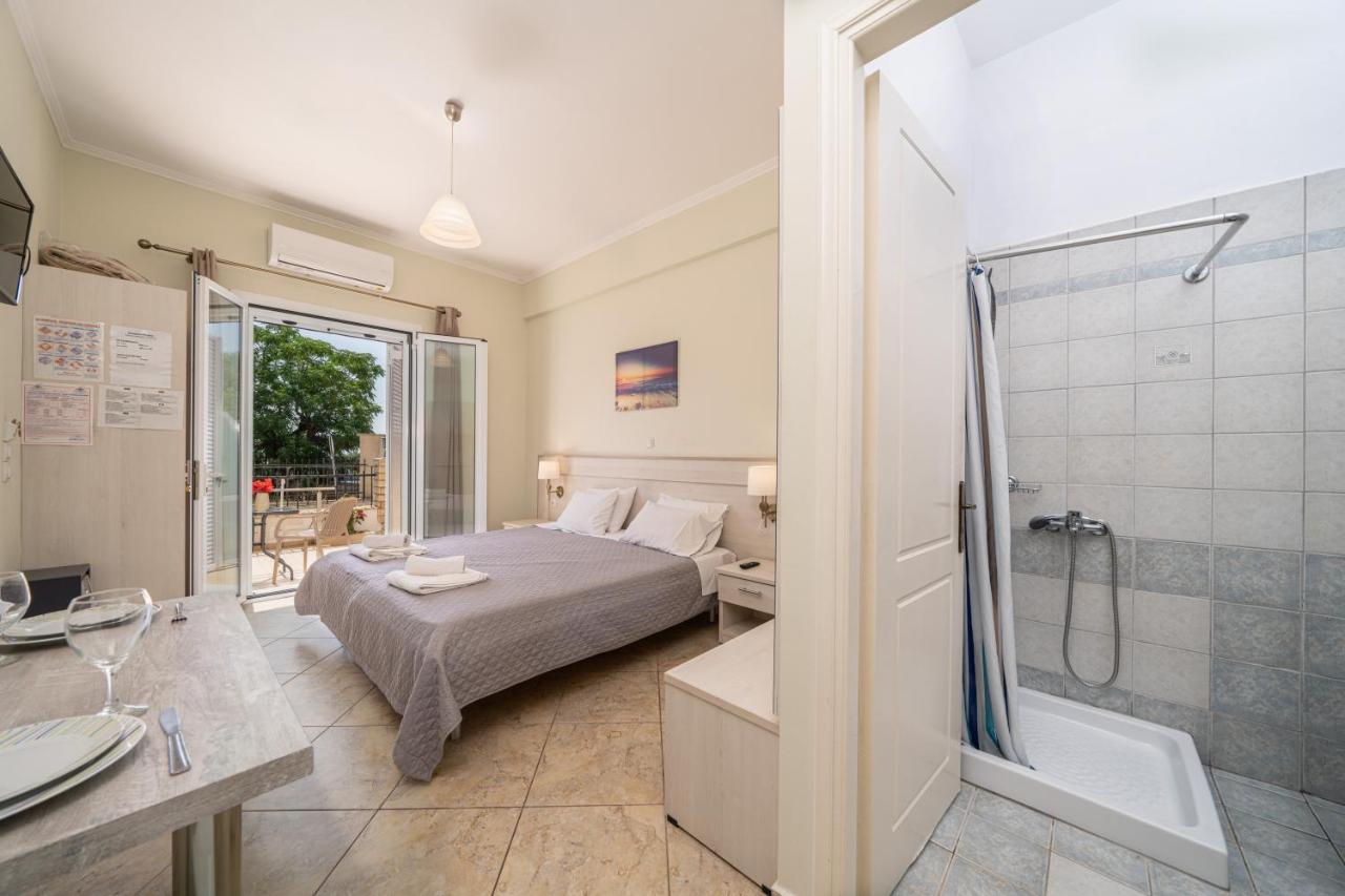 een slaapkamer met een bed en een badkamer met een douche bij Dionysios Studios in Skála Kefalonias