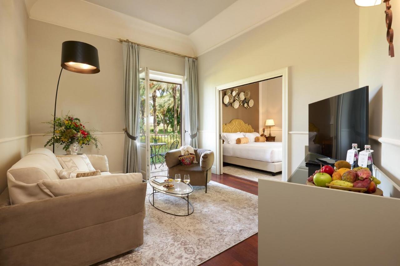 een woonkamer met een bank en een televisie bij Almar Giardino di Costanza Mazara del Vallo Resort & Spa in Mazara del V