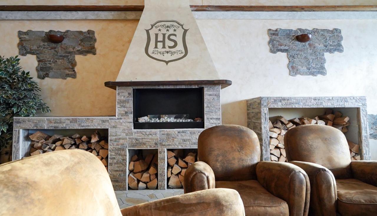 een woonkamer met twee stoelen en een open haard bij Hotel lo Stambecco in Breuil-Cervinia