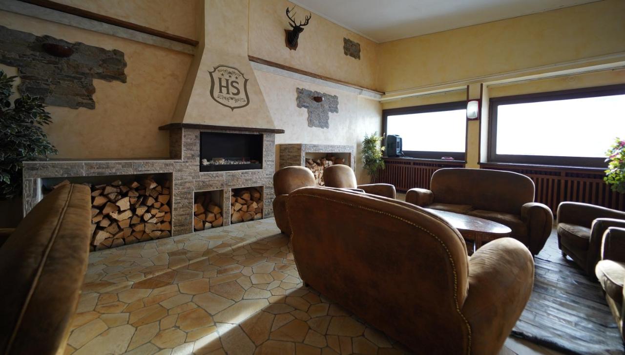 een wachtkamer met stoelen en een open haard bij Hotel lo Stambecco in Breuil-Cervinia