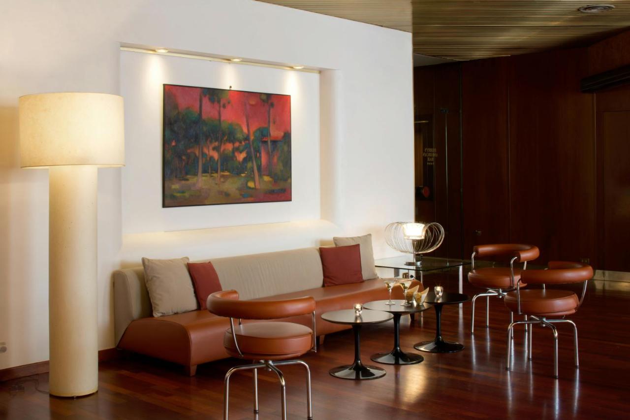 een woonkamer met een bank, een tafel en stoelen bij Starhotels Cristallo Palace in Bergamo