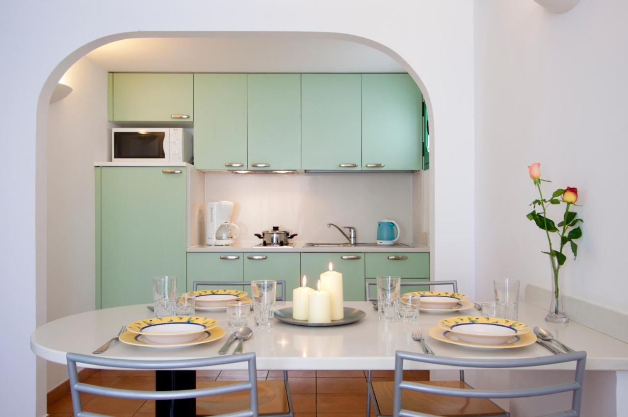 een keuken met een tafel met twee stoelen en groene keukenkastjes bij Bungalows Velázquez in Puerto del Carmen +29 foto'