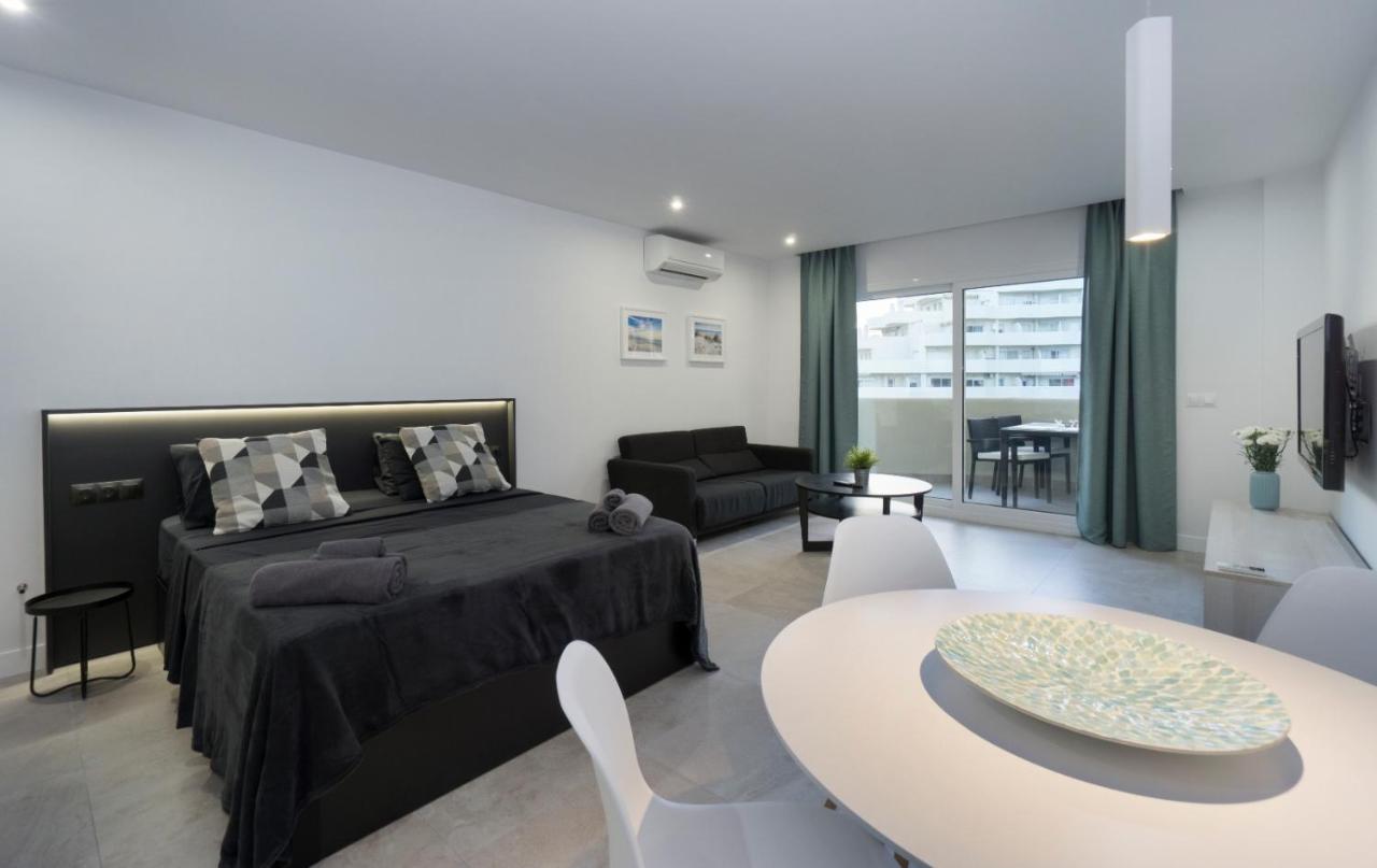 een slaapkamer met een bed en een woonkamer met een tafel bij Benalbeach in Benalmádena