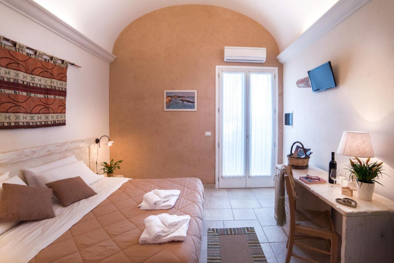 een slaapkamer met een bed, een bureau en een raam bij Relais Tenuta Campì in Martano