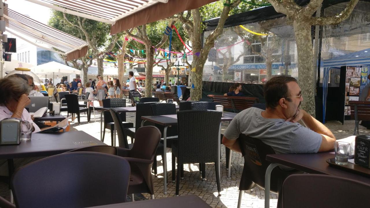 een man en een vrouw zitten aan tafels in een restaurant bij Ericeira Beach Haven in Ericeira