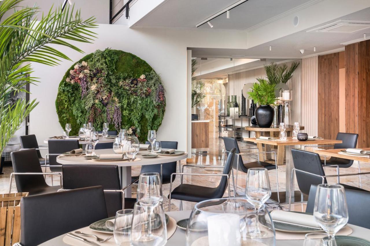 een restaurant met tafels en stoelen en een groot bloemstuk bij Salles Ciutat del Prat Barcelona Airport in El Prat de L