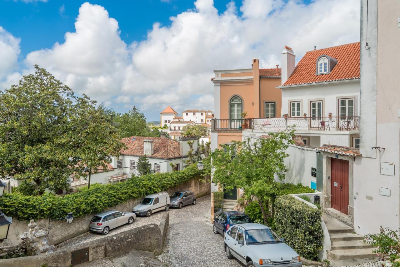 een straat in een stad met geparkeerde auto's bij Águamel Sintra, Boutique Guest House in Sintra
