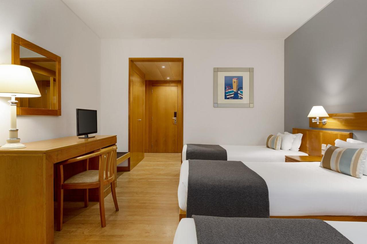 een hotelkamer met twee bedden en een bureau bij TRYP by Wyndham Montijo Parque Hotel in Montijo