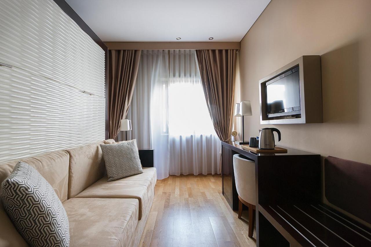 een woonkamer met een bank en een televisie bij Hotel Meira in Vila Praia de Âncora