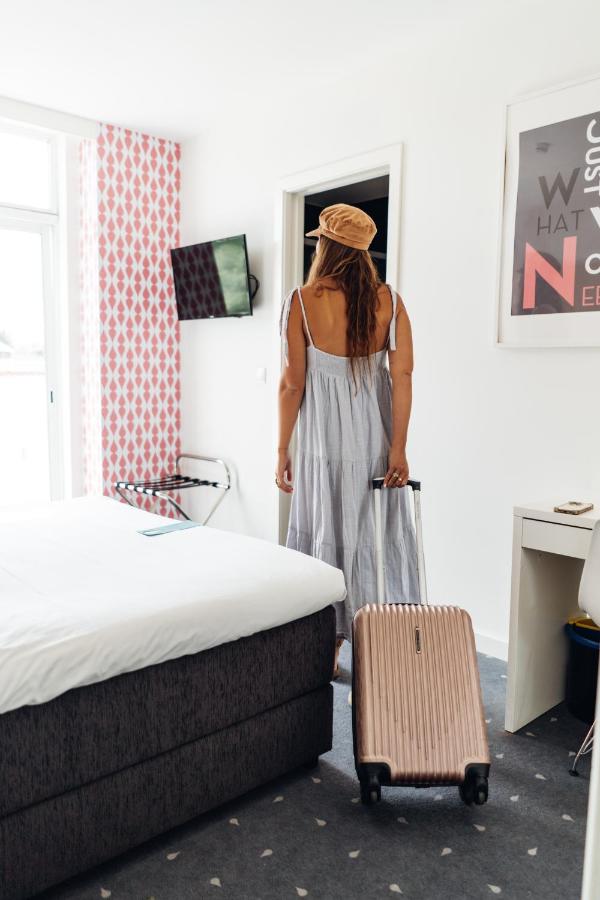 een vrouw staat naast een bed met een koffer bij Stay Hotel Lisboa Centro Saldanha in Lissabon +64 foto's