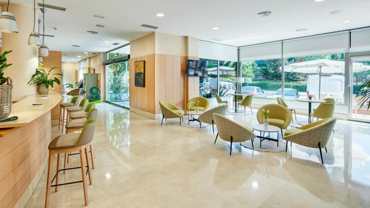 een lobby met stoelen, tafels en ramen bij Sercotel Porta Barcelona in Sant Just Desvern