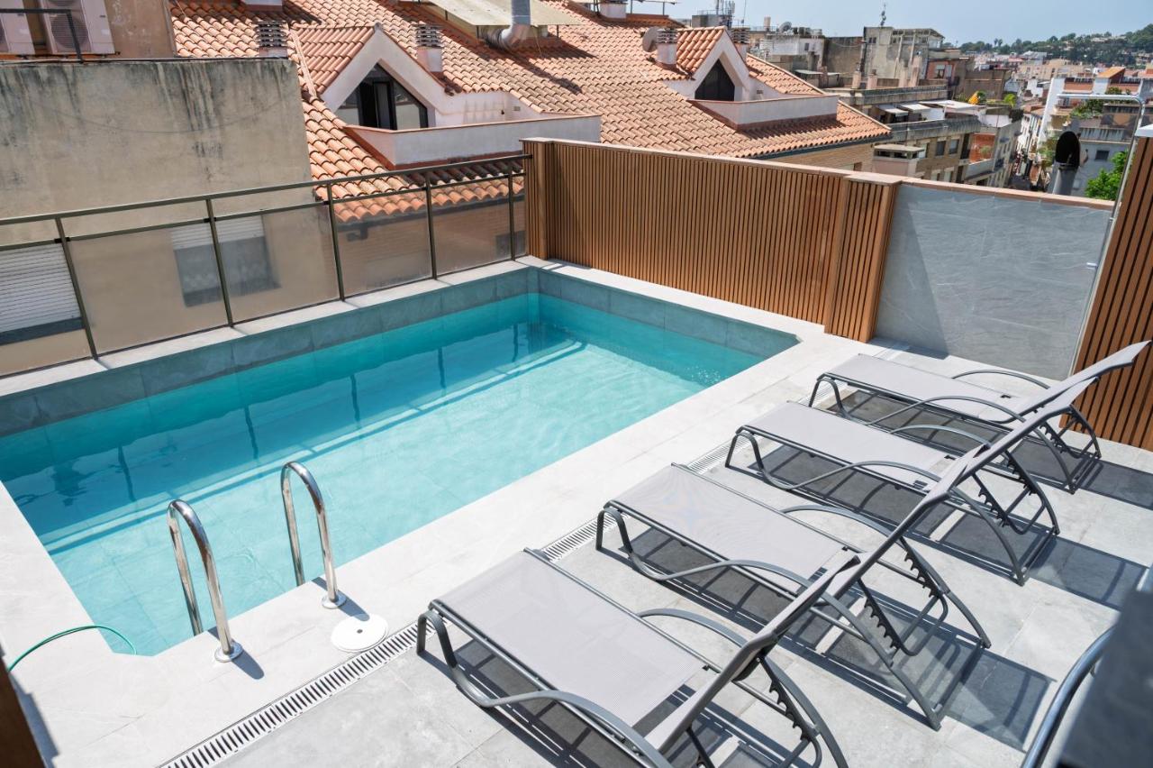 een zwembad met ligstoelen op een balkon bij Hotel Mefolinkel Suits in Lloret de Mar