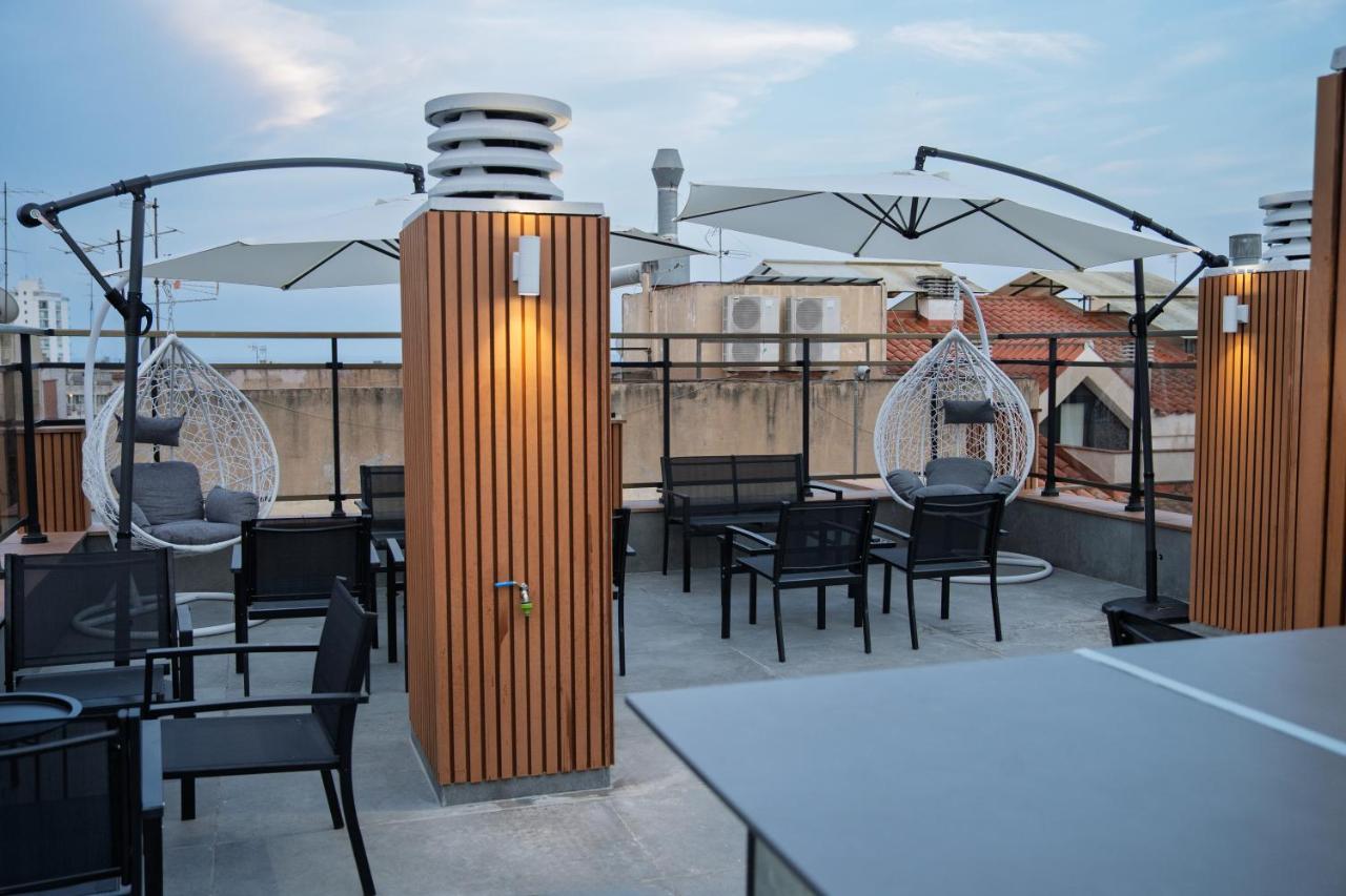 een terras met tafels en stoelen op een dakterras bij Hotel Mefolinkel Suits in Lloret de Mar +24 foto's
