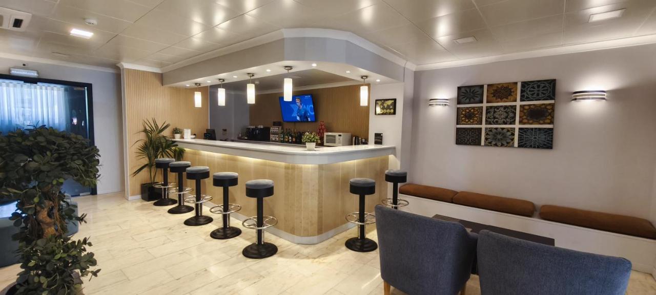 een bar met een rij krukken in een kamer bij Hotel São Mamede Estoril in Estoril