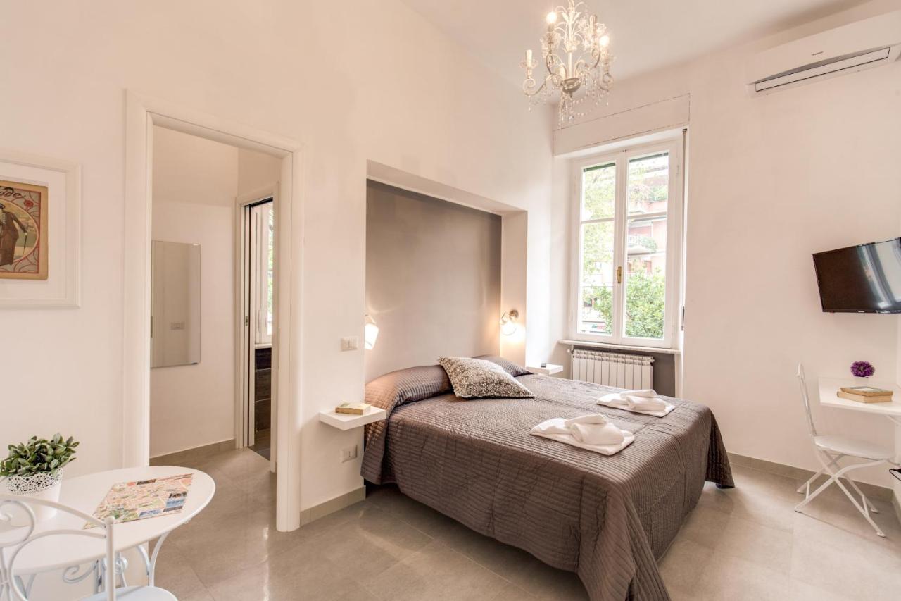 een witte slaapkamer met een bed, een tafel en stoelen bij Relais La Torretta in Rome