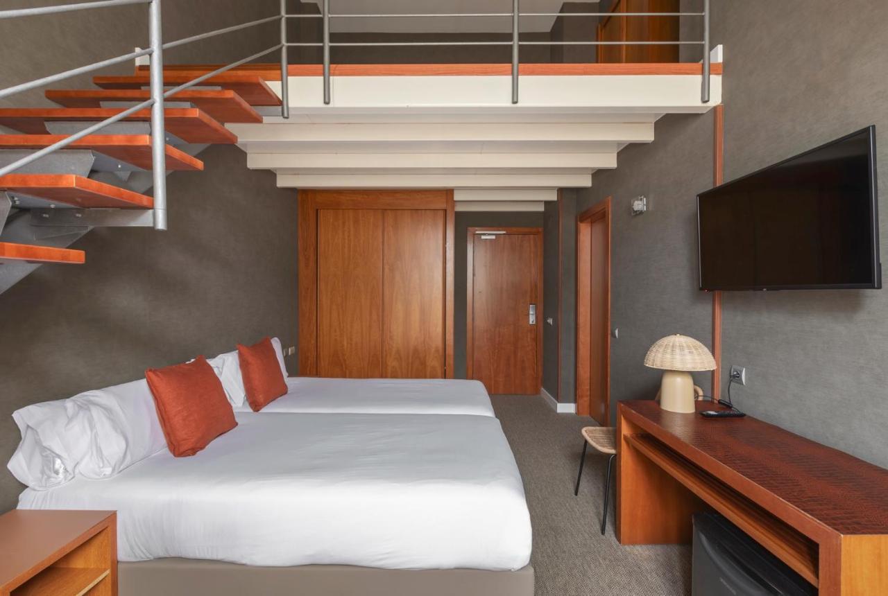 een slaapkamer met een bed en een trap bij Acta Sant Just in Sant Just Desvern