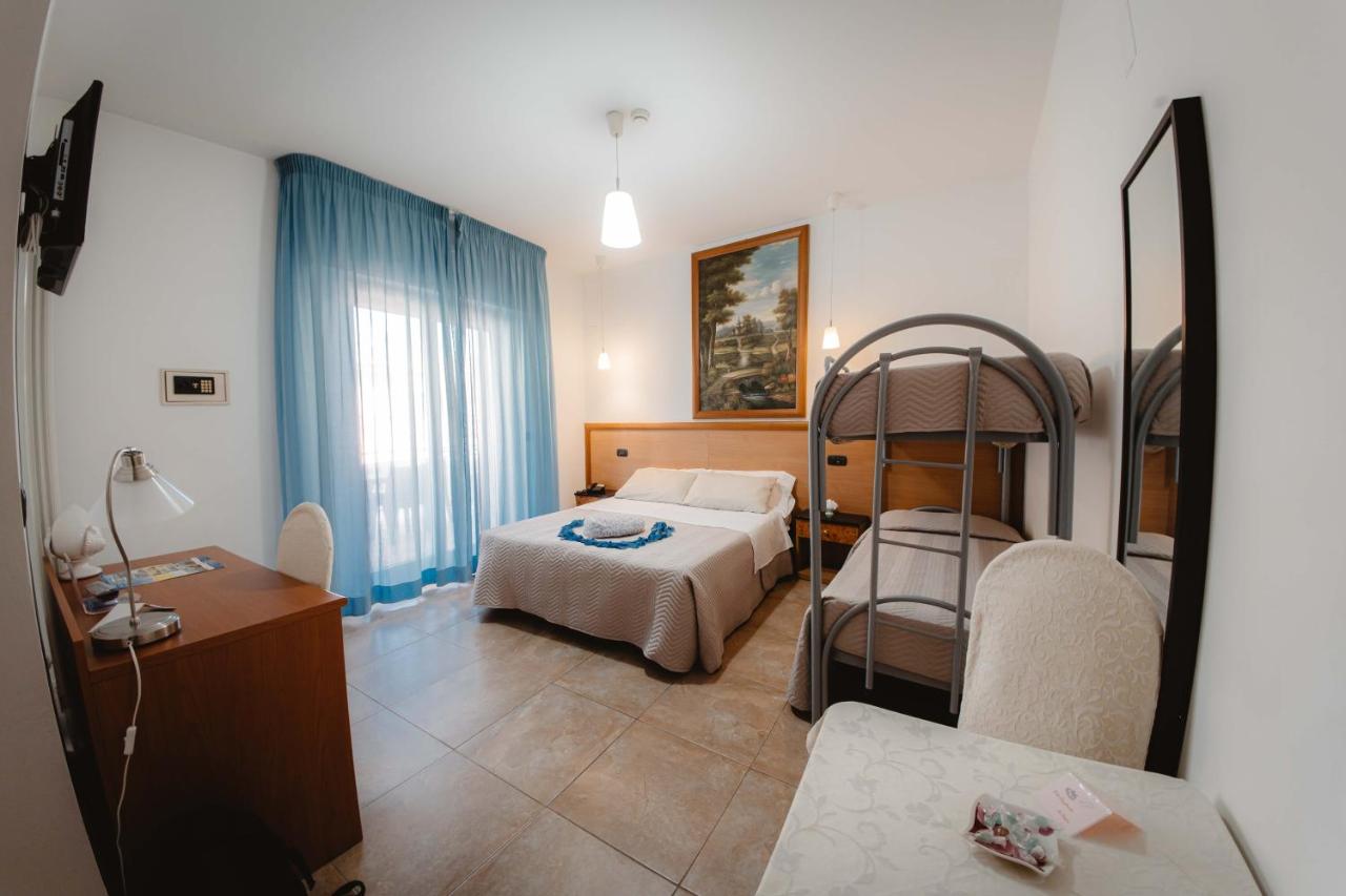 een slaapkamer met een bed en een stapelbed bij Hotel Accord Le Rose in Palagiano
