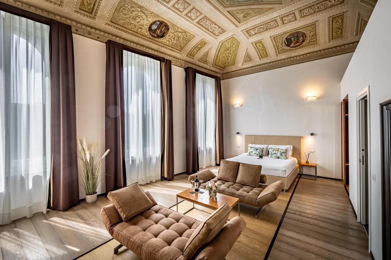 een slaapkamer met een bed, een bank en een tafel bij Palazzo Alfieri - Place of Charme in Florence