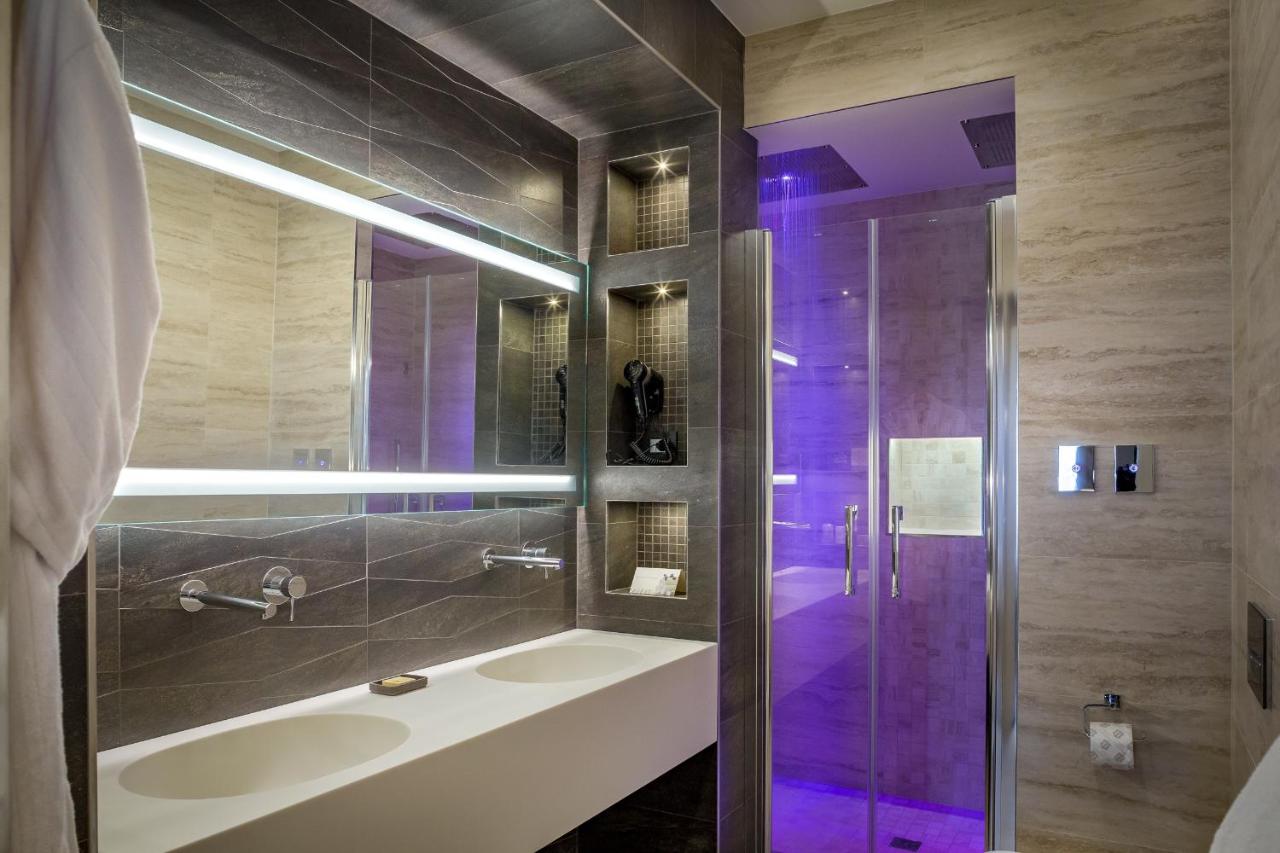 een badkamer met een wastafel en een douche met paarse verlichting bij Palazzo Alfieri - Place of Charme in Florence