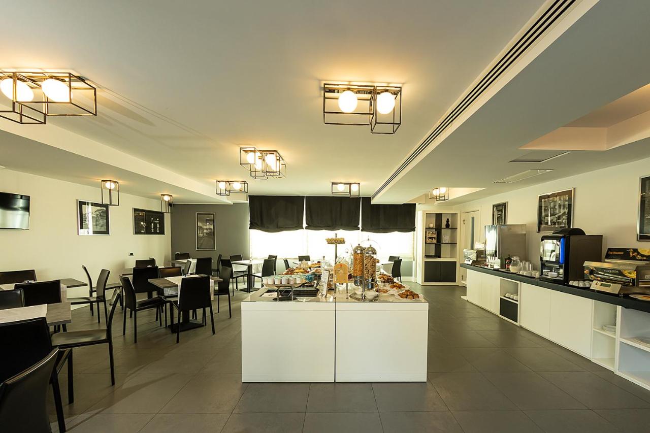een keuken en eetkamer met tafels en stoelen bij Best Western JFK Hotel in Napels +135 foto's