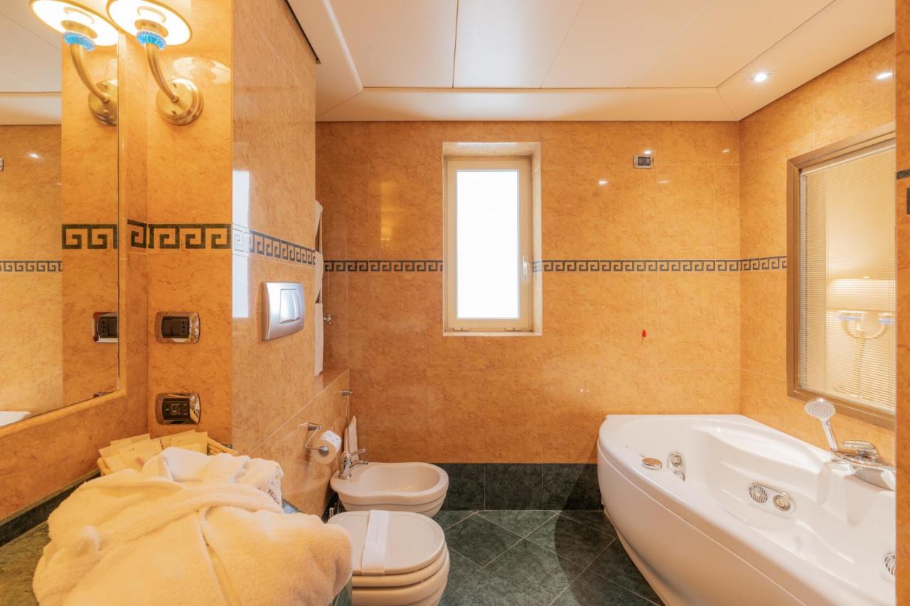 een badkamer met een toilet, een badkuip en een wastafel bij Hotel Pineta Palace in Rome