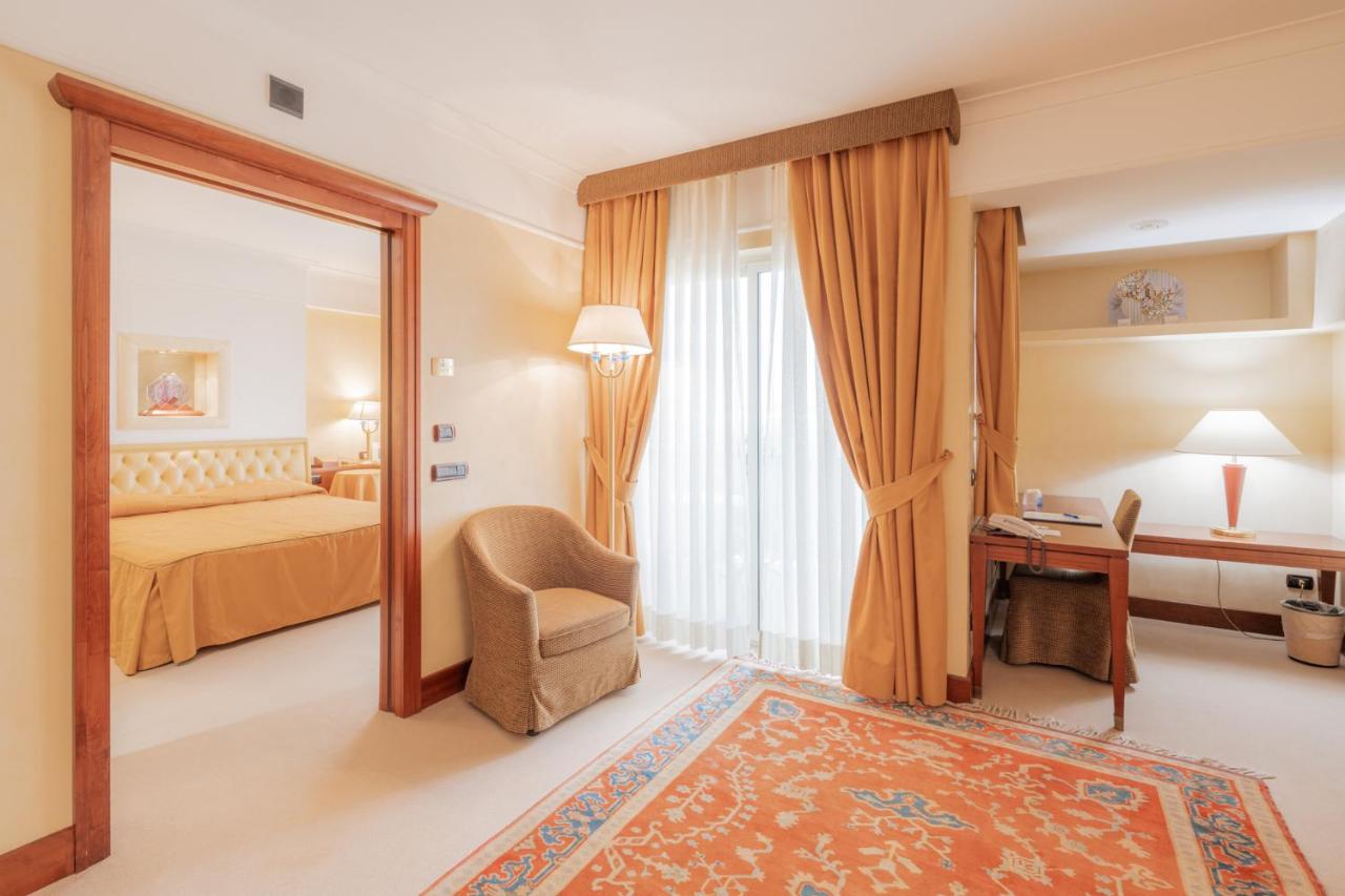 een hotelkamer met een bed en een spiegel bij Hotel Pineta Palace in Rome