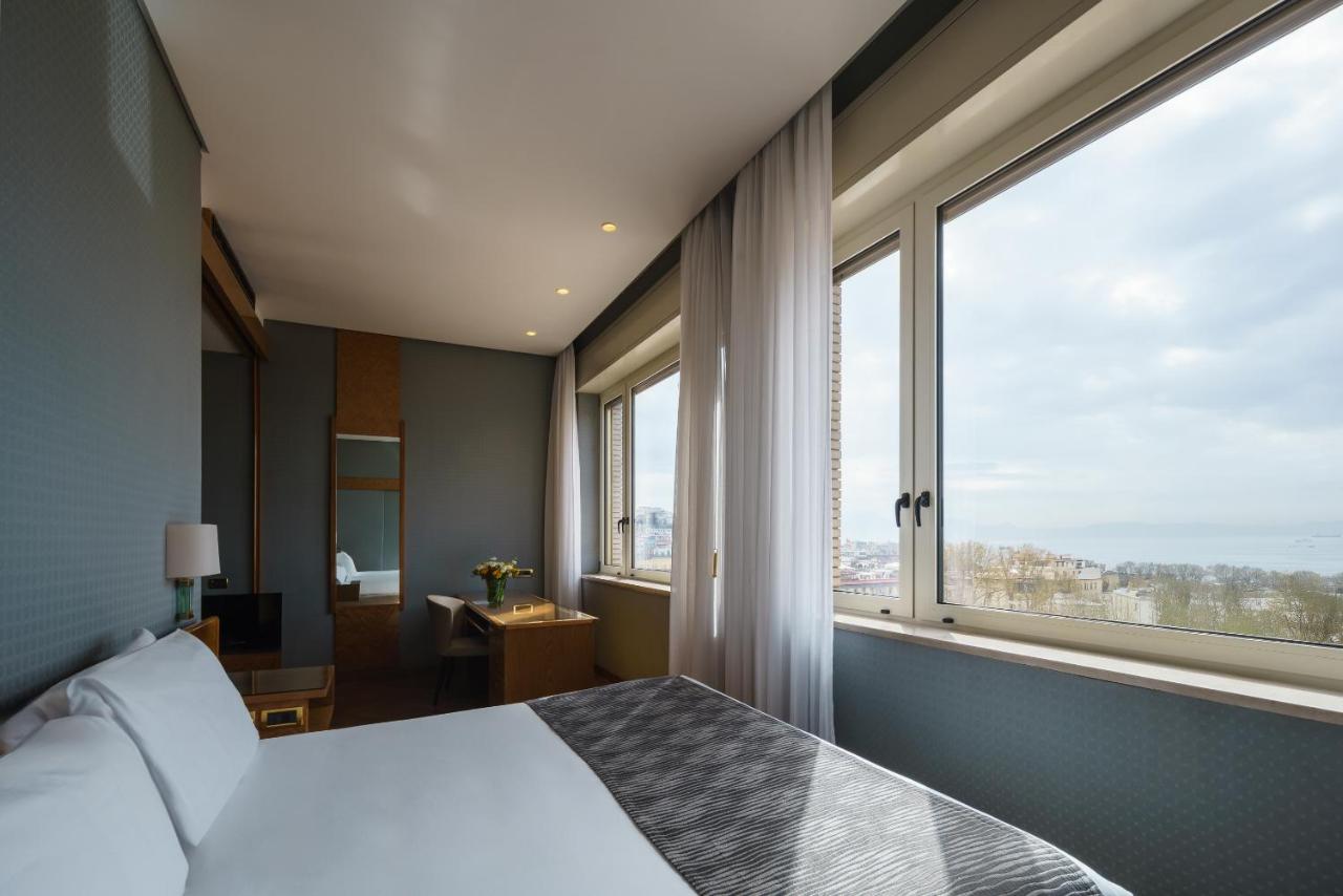 een slaapkamer met een bed en een groot raam bij Exe Majestic in Napels