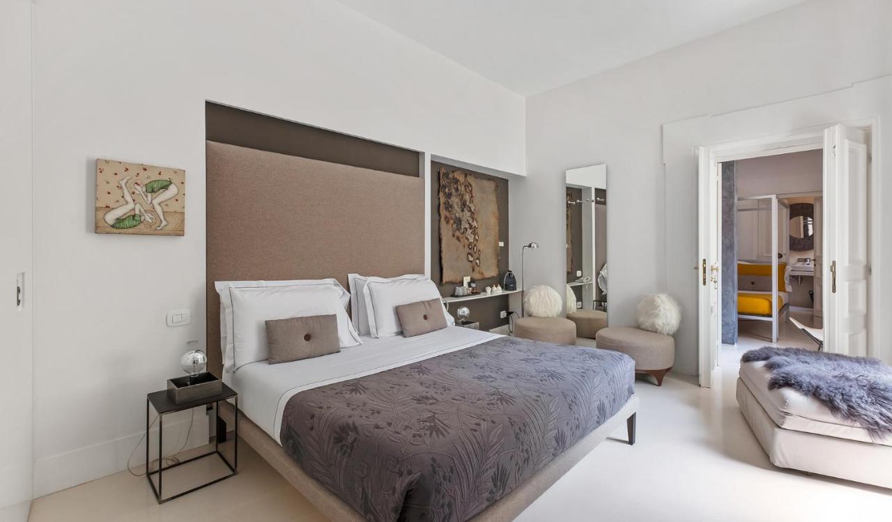 een witte slaapkamer met een groot bed en een stoel bij Piazza di Spagna 9 in Rome