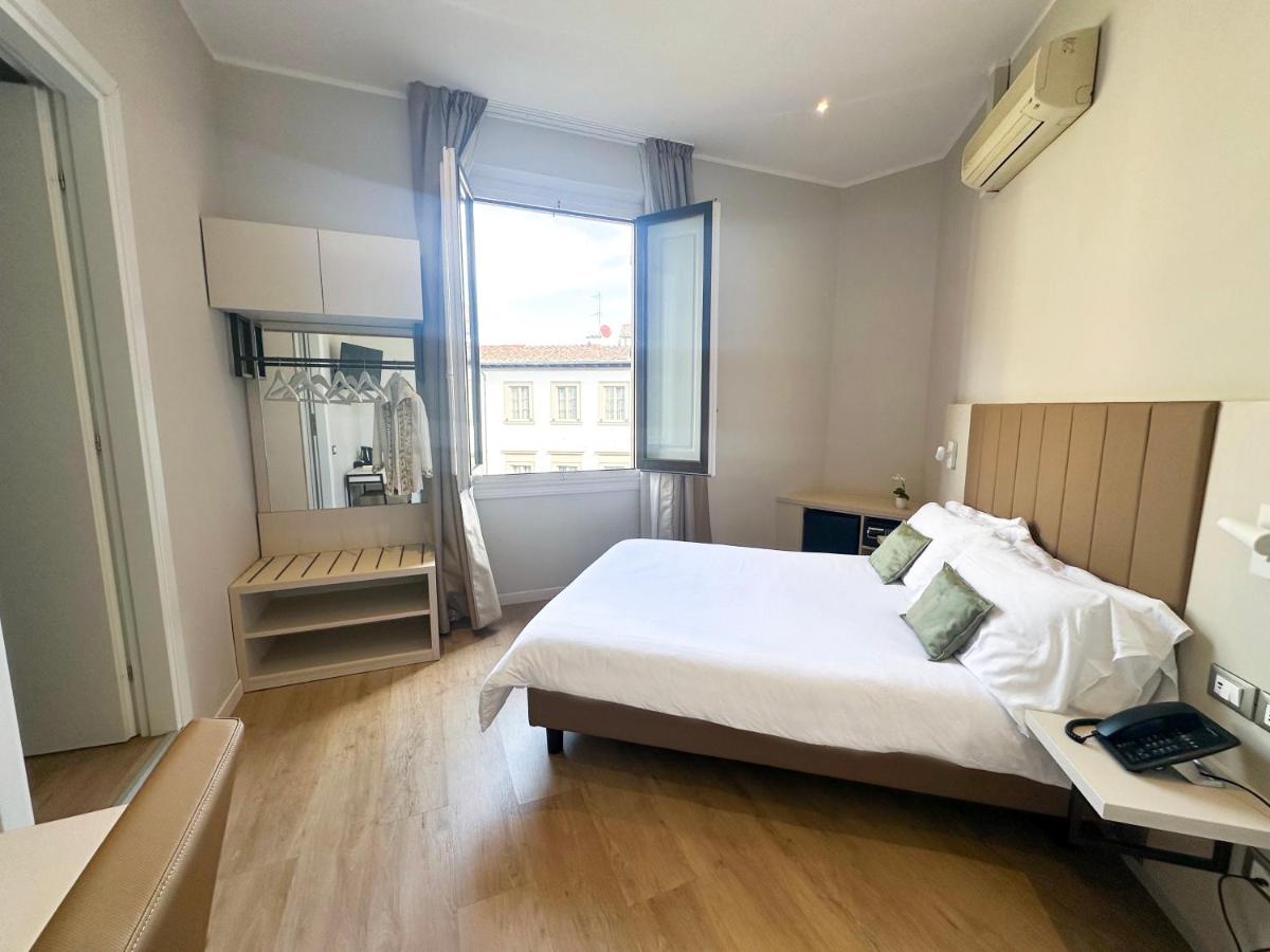 een slaapkamer met een bed, een bureau en een raam bij Hotel Giappone in Florence